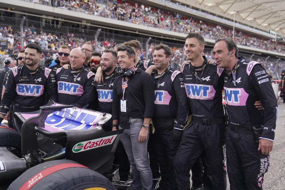 Rory McIlroy, center, of Northern Ireland, poses for a photo with the team of Alpine driver Esteban Ocon, of France, before the sprint ahead of the Formula One U.S. Grand Prix auto race at Circuit of the Americas, Saturday, Oct. 21, 2023, in Austin, Texas. (AP Photo/Darron Cummings)