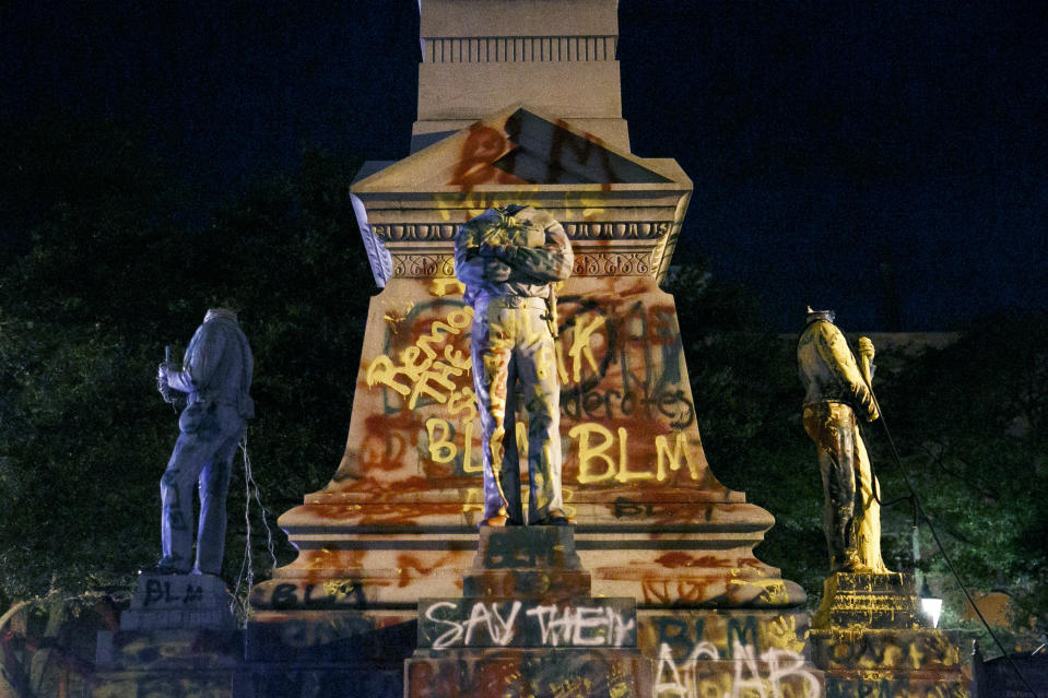 The statues on the Confederate monument are covered in graffiti and beheaded after a protest in Portsmouth, Va., Wednesday, June 10, 2020. Protesters beheaded and then pulled down four statues that were part of a Confederate monument. The crowd was frustrated by the Portsmouth City Council’s decision to put off moving the monument. (Kristen Zeis/The Virginian-Pilot via AP)