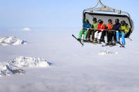 Skiers are seen on a cable car above the fog on December 1, 2012 in the Titlis mountain above Engelberg, Central Switzerland. AFP PHOTO / FABRICE COFFRINI