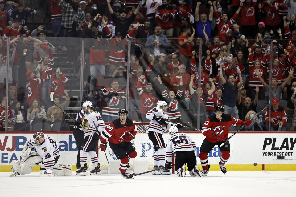 New Jersey Devils center Jack Hughes (86) celebrates after scoring past Chicago Blackhawks goaltender Kevin Lankinen (32) in overtime of an NHL hockey game Friday, Oct. 15, 2021, in Newark, N.J. The Devils won 4-3. (AP Photo/Adam Hunger)