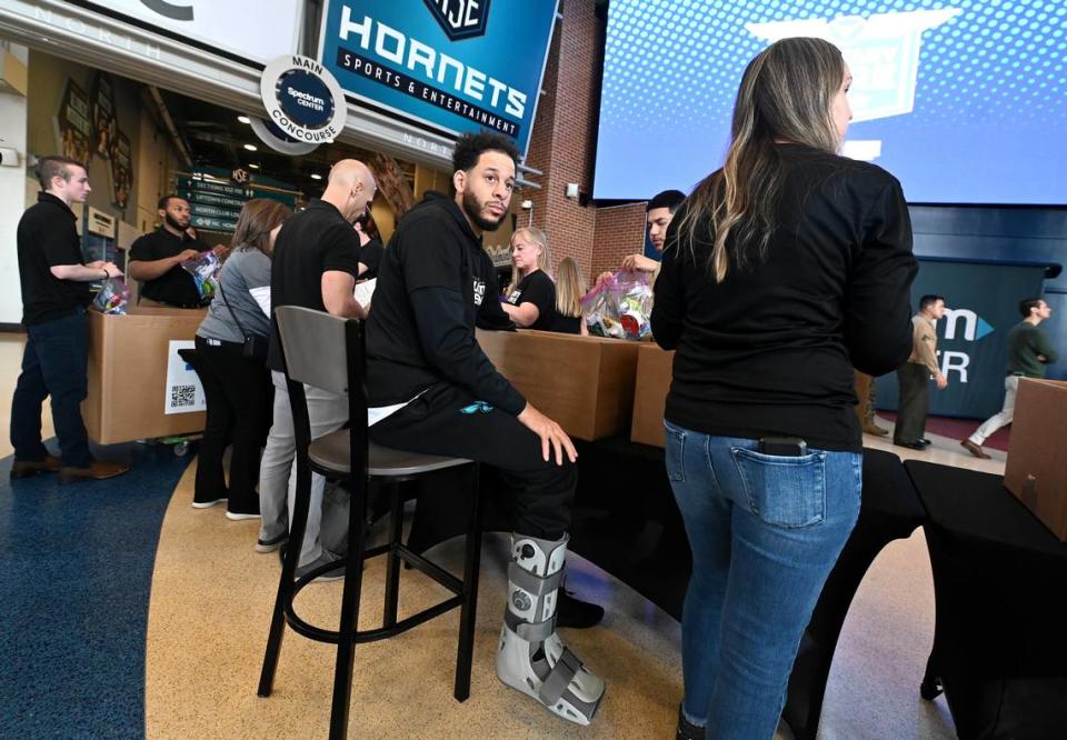 Charlotte Hornets guard Seth Curry, center, wears a walking boot on his right leg during the team and Novant Health’s Military Care event at Spectrum Center on Monday, March 4, 2024. JEFF SINER/jsiner@charlotteobserver.com