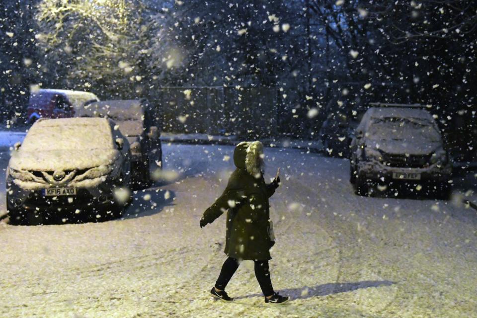 A woman walks through a snow shower in London on Tuesday (EPA)