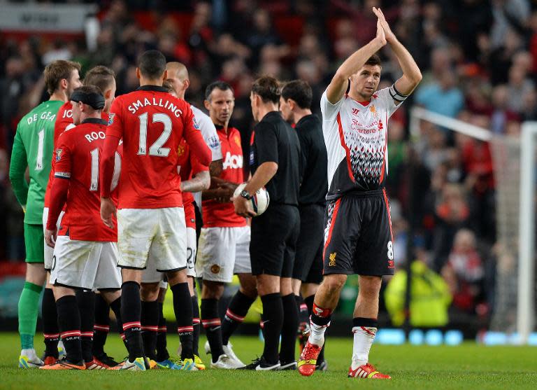 Liverpool's Steven Gerrard (R) appaluds the Liverpool fans at Old Trafford in Manchester on September 25, 2013