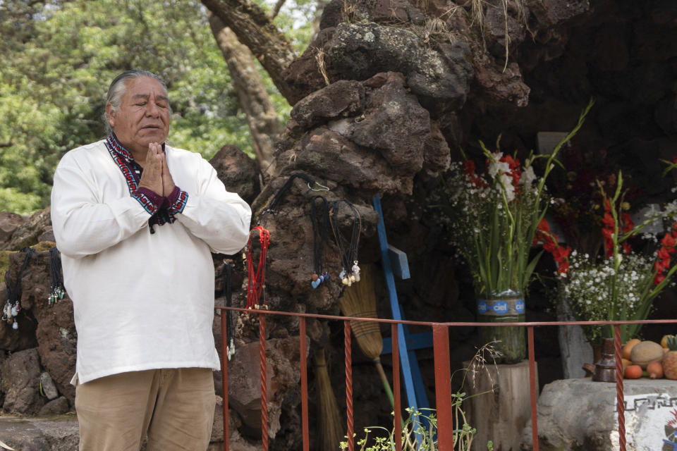 Moisés Vega agradece por los visitantes del Museo del Volcán junto a una réplica del santuario que la gente le dedica al volcán Popocatépetl, en Amecameca, México, el domingo 11 de junio de 2023. Vega, un granicero, practica rituales tres veces al año para pedir a los volcanes por buen tiempo y la cantidad justa de lluvia que necesitan las cosechas. (AP Foto/Áurea Del Rosario)