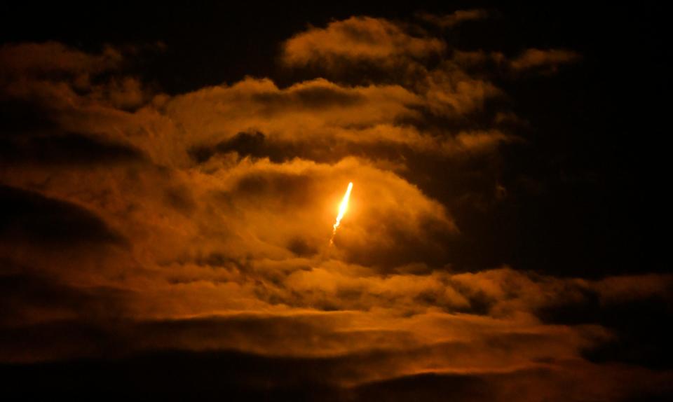 Saturday's SpaceX Falcon 9 casts an orange glow on clouds as viewed from Viera.