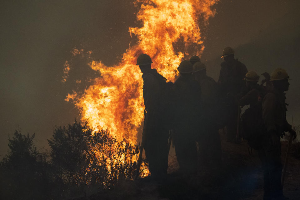 Firefighters monitor a controlled burn along Nacimiento-Fergusson Road to help contain the Dolan Fire near Big Sur, Calif., Friday, Sept. 11, 2020. (AP Photo/Nic Coury)