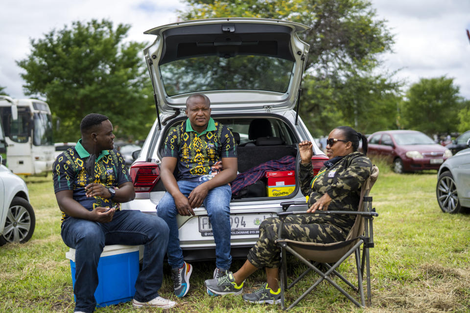 African National Congress party (ANC) supporters who could not access the party's 110th birthday celebration at Polokwane's Peter Mokaba stadium, sit by their car, in Polokwane, South Africa, Saturday Jan. 8, 2022. Because of coronavirus regulations, only 2000 could attend the anniversary , amid deep divisions, graft allegations and broad challenges that saw the ANC perform dismally in local government elections last year. (AP Photo/Jerome Delay)