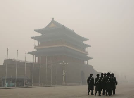 Paramilitary soldiers walk past the Zhengyangmen gate as they patrol at the Tiananmen Square during a heavily polluted day in Beijing, China November 30, 2015. REUTERS/Kim Kyung-Hoon