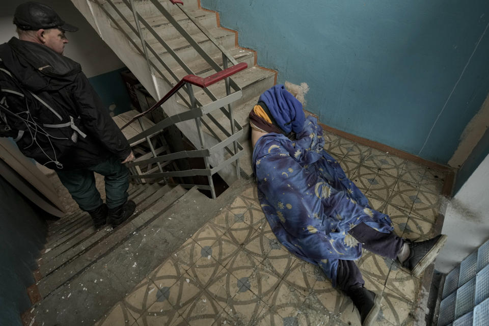 FILE - The body of a man who was killed lies on the staircase of a building in Bucha, Ukraine, April 3, 2022. The scenes that emerged from this town near Kyiv a year ago after it was retaken from Russian forces have indelibly linked its name to the savagery of war. Bodies of civilians lay where they had fallen, more bodies were found inside homes, others were unearthed from a mass grave. (AP Photo/Vadim Ghirda, File)