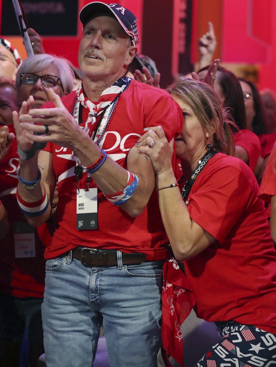 Christina Dressel, right, mother of Caeleb Dressel, hides as she can barely watch Friday, July 30, 2021, in Orlando, Fla., as her son wins the gold medal in the men's swimming 100-meter butterfly at the Tokyo Olympics. (Stephen M. Dowell/Orlando Sentinel via AP)