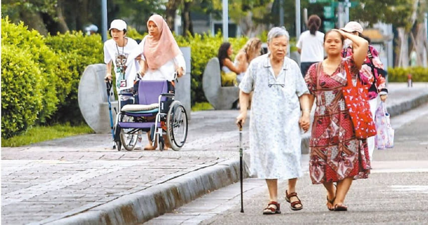 行動不便的長者在移工照護下在公園散步，雇主團體及身障團體認為應放寬看護工資格，引進大量移工，滿足所有長照需求。（圖／中國時報鄧博仁攝）