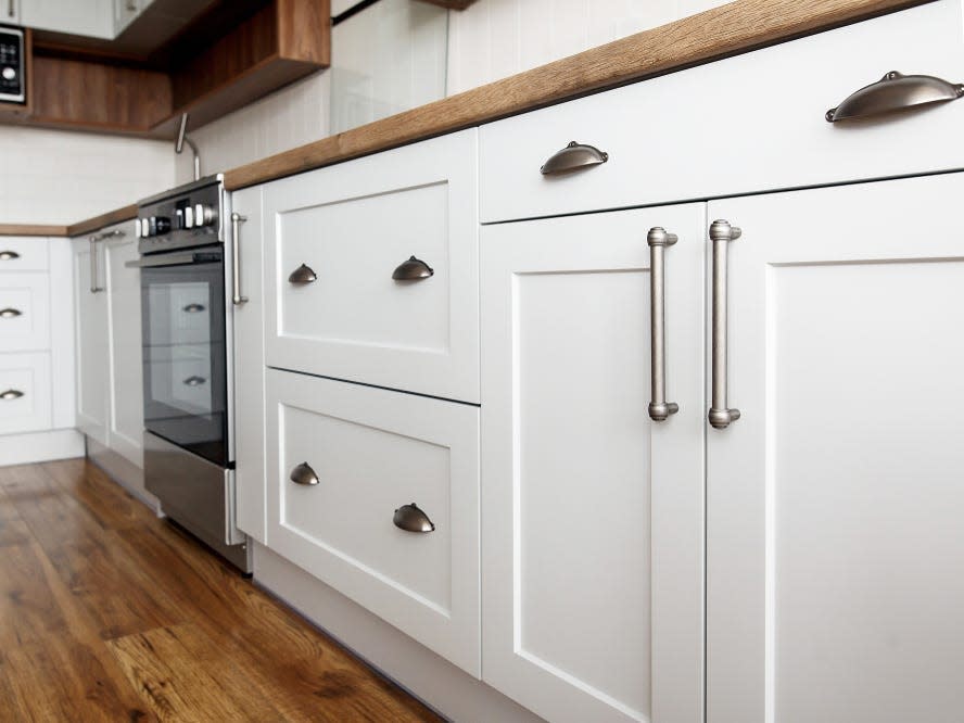 white lower cabinets in kitchen with silver handles