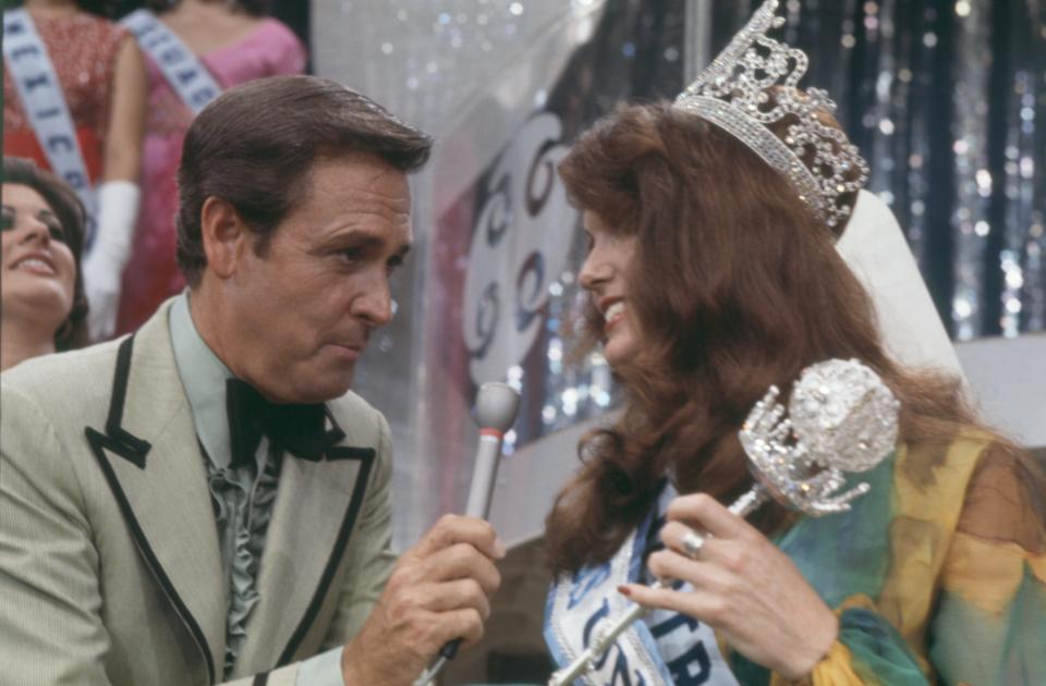 Miss Universe of 1972, wearing her crown and carrying her sceptre, Miss Kerry Anna Wells, 20, of Perth, Australia, talks with the Master of Ceremonies of the Miss Universe Pageant, Bob Barker