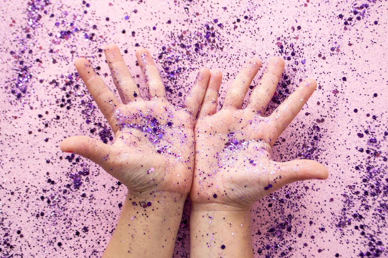 Child's hands with purple color glitter