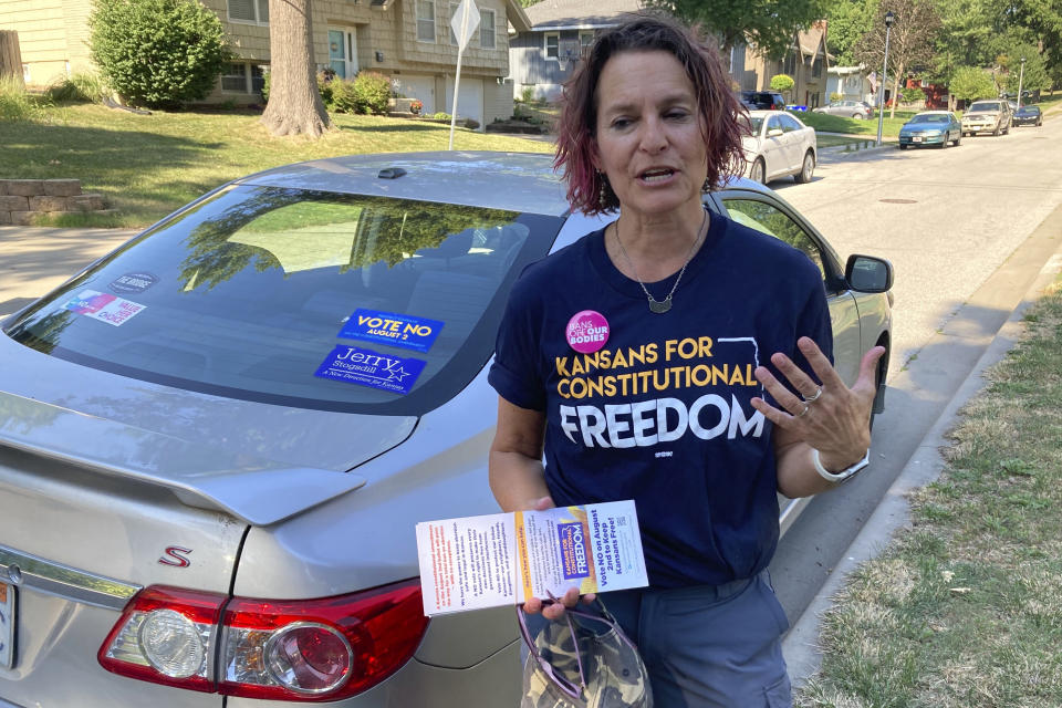 In this photo from Thursday, July 14, 2022, Anne Melia discusses her opposition to a proposed amendment to the Kansas Constitution that would allow legislators to further restrict or ban abortion before she goes door-to-door to talk to prospective voters in Merriam, Kansas. Melia is a Democrat and community activist who is working with the campaign against the proposed amendment. (AP Photo/John Hanna)