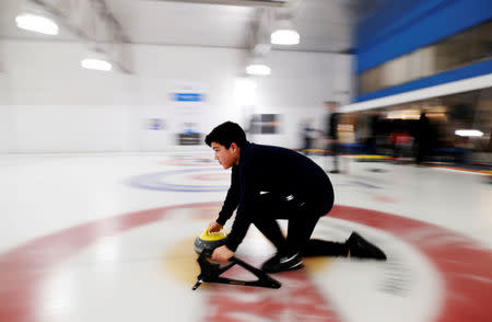 An refugee from Afghanistan throws the rock as he learns to curl at the Royal Canadian Curling Club during an event put on by the "Together Project", in Toronto, March 15, 2017. REUTERS/Mark Blinch