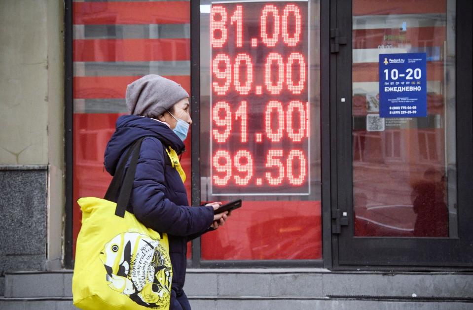 <span class="caption">The ruble crashed to a record low after Russia invaded Ukraine and the West announced new sanctions.</span> <span class="attribution"><a class="link " href="https://www.gettyimages.com/detail/news-photo/woman-walks-past-a-currency-exchange-office-in-central-news-photo/1238722510?adppopup=true" rel="nofollow noopener" target="_blank" data-ylk="slk:Alexander Nemenov/AFP via Getty Images);elm:context_link;itc:0;sec:content-canvas">Alexander Nemenov/AFP via Getty Images)</a></span>