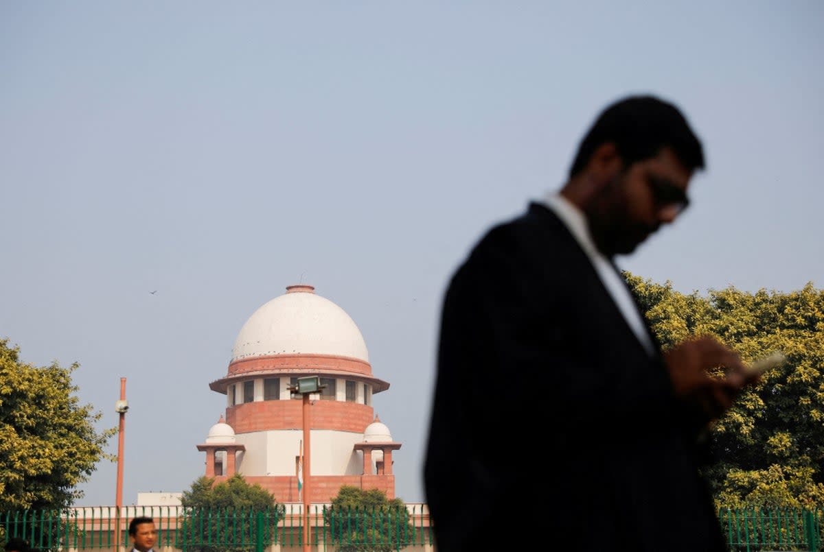 File: A lawyer looks at his mobile phone in front India's supreme court in New Delhi (Reuters)