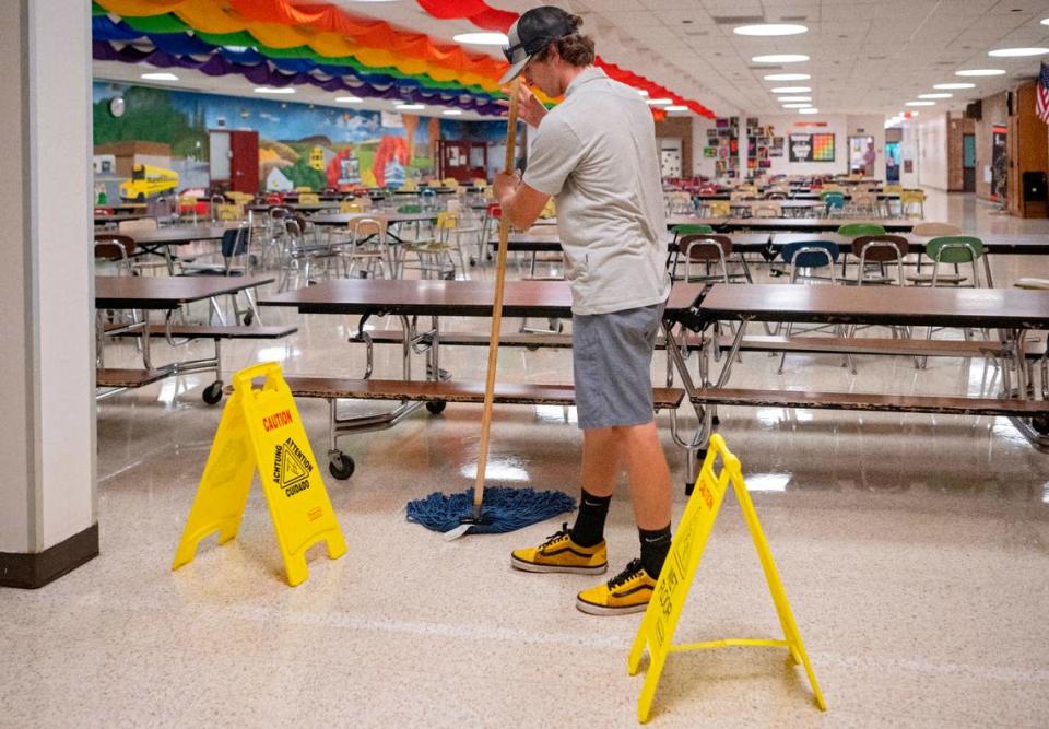 Gabe Cantolina, a custodian at Park Forest Middle School, cleans up a spill int he cafeteria on the first day of school day on Aug. 22.