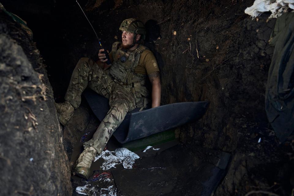 A Ukrainian soldier sits in a trench on the front line (AP)