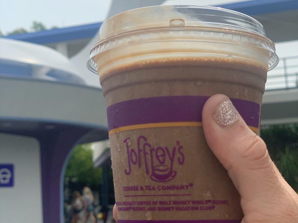 hand holding cup of joffrey's coffee in tomorrowland at disney world