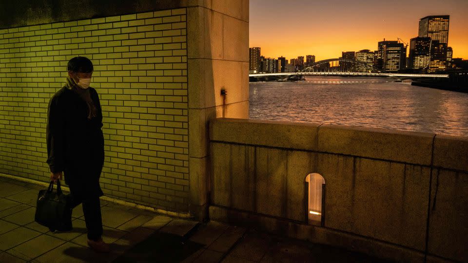 A man walks on a bridge in the faint light of sunset in Tokyo on December 20, 2022. Residents of Japan's capital city will get nine hours and 44 minutes of daylight on winter solstice. - Yuichi Yamazaki/AFP/Getty Images