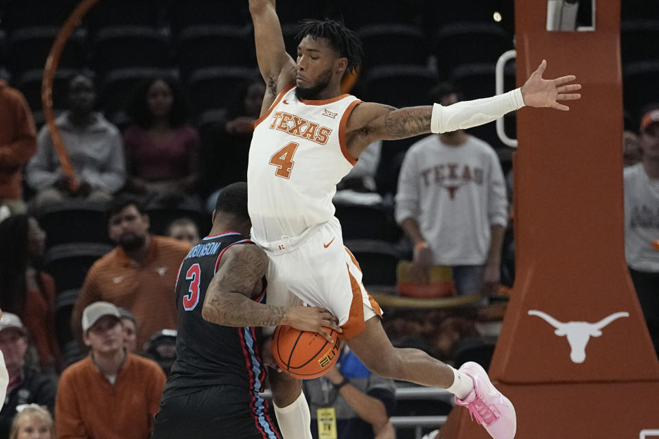 Delaware State guard Martaz Robinson (3) is fouled by Texas guard Tyrese Hunter (4) as he drives to the basket during the second half of an NCAA college basketball game, Friday, Nov. 10, 2023, in Austin, Texas. (AP Photo/Eric Gay)