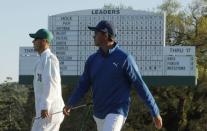 Rickie Fowler of the U.S. walks up the 18th green past the leaderboard in second round play during the 2017 Masters golf tournament at Augusta National Golf Club in Augusta, Georgia, U.S., April 7, 2017. REUTERS/Brian Snyder