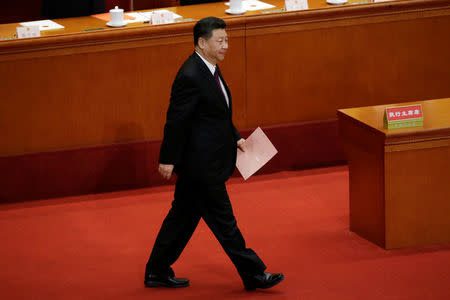 Chinese President Xi Jinping walks with his ballot before a vote at the fifth plenary session of the National People's Congress (NPC) at the Great Hall of the People in Beijing, China March 17, 2018. REUTERS/Jason Lee