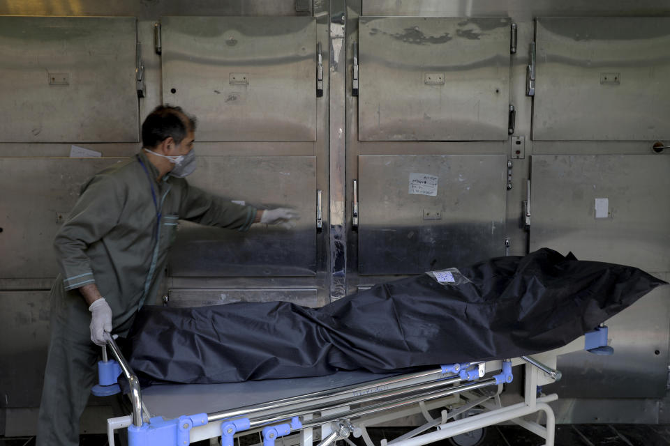 A hospital worker moves the body of a patient who died from COVID-19, at the morgue of the Shohadaye Tajrish Hospital in Tehran, Iran, Sunday, April 18, 2021. After facing criticism for downplaying the virus last year, authorities have put partial lockdowns and other measures in place to try and slow the coronavirus’ spread, as Iran faces what looks like its worst wave of the coronavirus pandemic yet. (AP Photo/Ebrahim Noroozi)