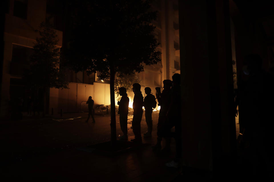 Lebanese soldiers stand guard as anti-government protesters throw stones and clash with the riot police, during a protest against the political elites who have ruled the country for decades, in Beirut, Lebanon, Thursday, Aug. 6, 2020. (AP Photo/Hassan Ammar)