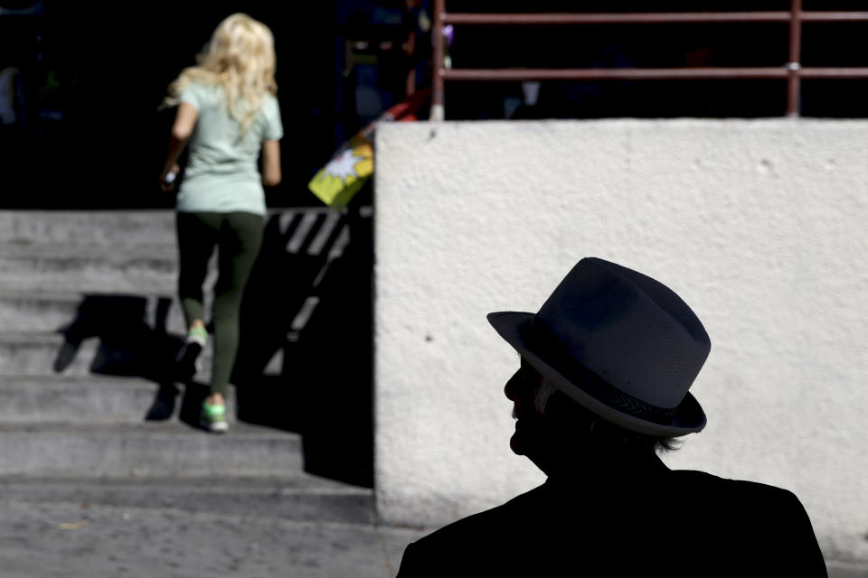 A man rests in the shadow of a bus stop on Monday, May 12, 2014, in Los Angeles. A warm weekend was expected to give way to a sweltering work week in SouthernCalifornia, with whipping winds of the sort already felt across the West bringing dry conditions and high fire danger. (AP Photo)