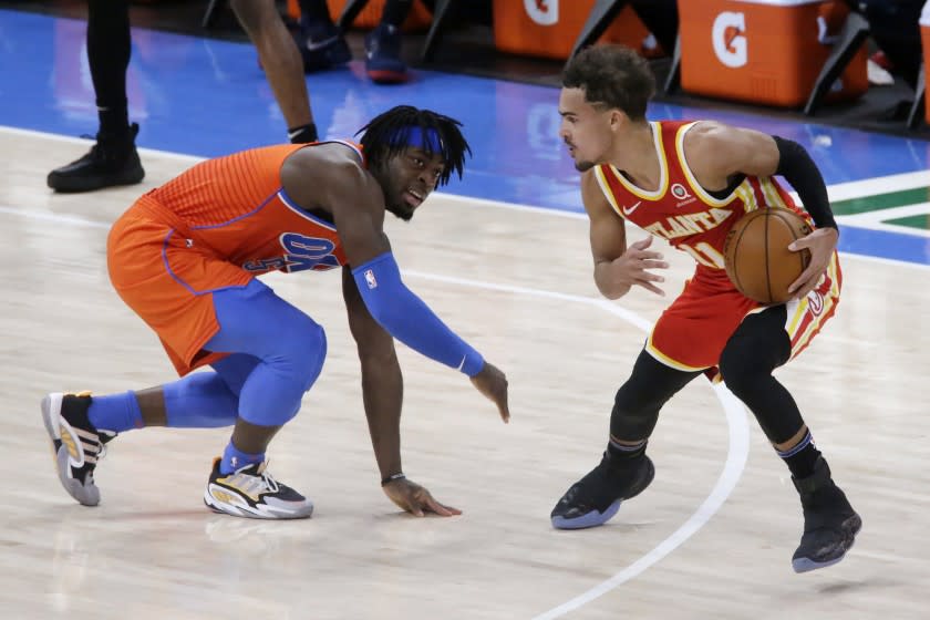 Atlanta Hawks guard Trae Young (11) is defended by Oklahoma City Thunder forward Luguentz Dort.