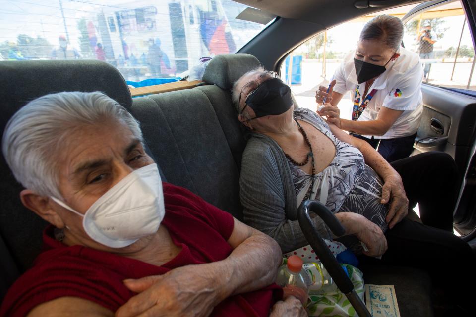 Alejandra Muñoz, a nurse with the Chihuahua Health Department administers a COVID-19 vaccination to Maria de la Luz Gutierrez Sanchez, 80 as her sister, Antonia Gutierrez Perez, 84 in Ciudad Juarez on April 12, 2021.