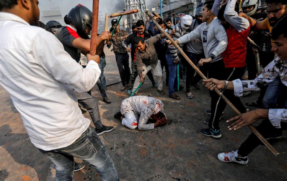 Hindu nationalists beat a Muslim man, Mohammad Zubair, during protests in New Delhi in February 2020: Siddiqui, who was forced to flee the situation, later tracked the man down to apologise for leaving him to his fate - Danish Siddiqui/Reuters