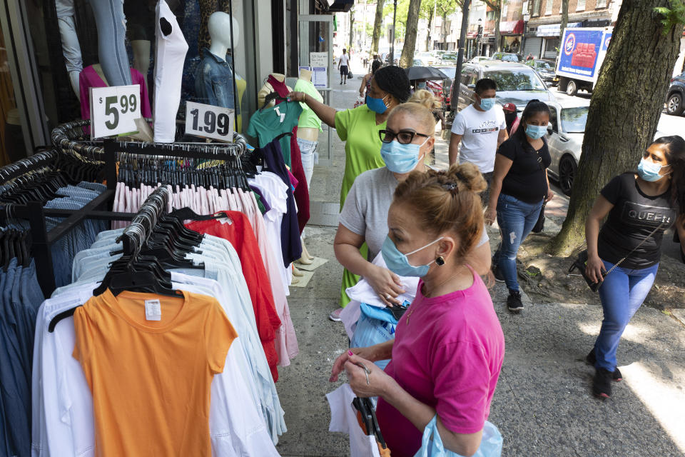 Customers shop at Ashley 21 clothing store, Tuesday, June 9, 2020, in Mount Vernon, N.Y. Counties north of New York City are reopening clothing stores as part of Phase 2 during the coronavirus pandemic. (AP Photo/Mark Lennihan)