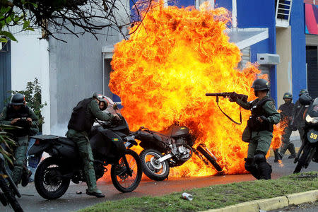 Riot security forces clash with demonstrators as a motorcycle is set on fire during a protest against Venezuelan President Nicolas Maduro's government in San Cristobal, Venezuela May 29, 2017. REUTERS/Carlos Eduardo Ramirez