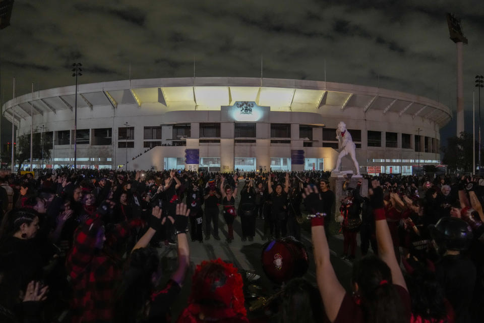 FILE - Musicians and dancers perform in front of the National Stadium, which served as a detention and torture center in the early days of the military dictatorship, during a vigil marking the 50th anniversary of the 1973 military coup that toppled the government of late President Salvador Allende, in Santiago, Chile, Monday, Sept. 11, 2023. Historians estimate that between 20,000 and 40,000 people spent some time locked up in fear at the stadium 50 years ago when it was used for torture and extra judicial killings. (AP Photo/Esteban Felix, File)