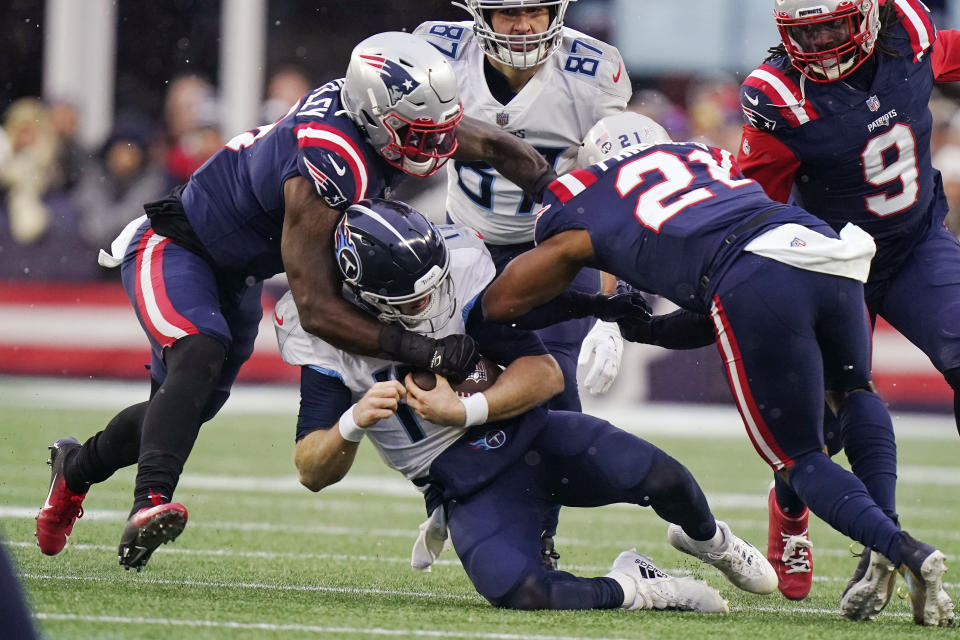 Tennessee Titans quarterback Ryan Tannehill, center, is brought down by New England Patriots middle linebacker Ja'Whaun Bentley, left, and safety Adrian Phillips (21) during the second half of an NFL football game, Sunday, Nov. 28, 2021, in Foxborough, Mass. (AP Photo/Steven Senne)