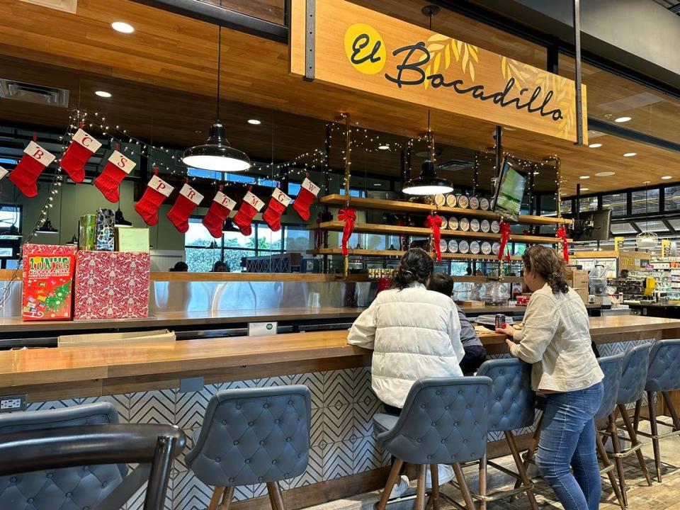 Whole Foods’ El Bocadillo bars inside the seated cafe area at Whole Foods supermarkets give customers like the Garcia family, seen here on Nov. 7, 2023, at the 7930 SW 104th St. location in Pinecrest Plaza near Kendall a place to eat during the grocery shopping experience.