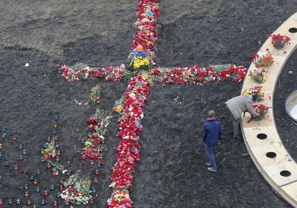 Personas colocan flores y velas en el lugar donde hubo enfrentamientos letales entre manifestantes de la oposición y la policía antidisturbios en el centro de Kiev, Ucrania, el sábado 1 de marzo de 2014. (Foto AP/Efrem Lukatsky)
