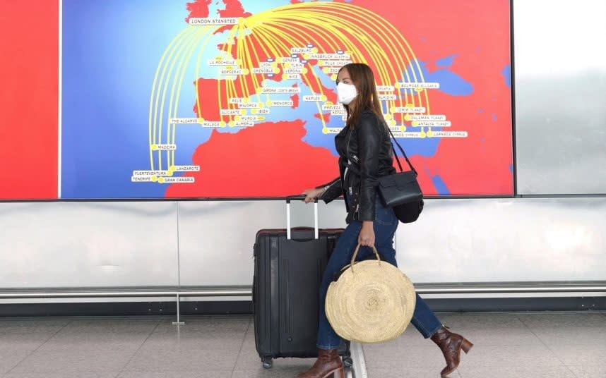 Holiday-ready? An air passenger passes through Stansted Airport today. CREDIT: ALAMY - Alamy