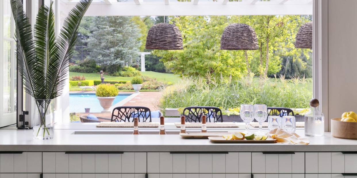 open bar with the windows folded open, adults can keep an eye on swimming kids—and easily pass through snacks drinks are sunk into a slim trough cut into the countertop and stocked with ice pendants lightology chairs janus et cie hardware rocky mountain hardware