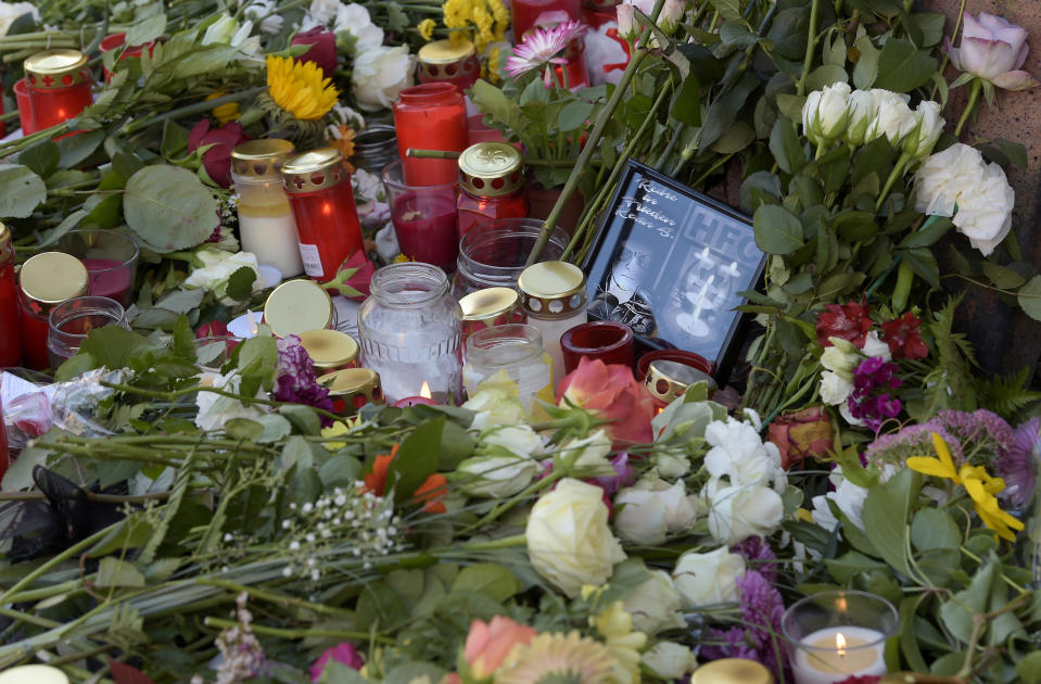 Flowers and candles are placed in front of of a kebab grill in Halle, Germany, Thursday, Oct. 10, 2019. A heavily armed assailant ranting about Jews tried to force his way into a synagogue in Germany on Yom Kippur, Judaism's holiest day, then shot two people to death nearby in an attack Wednesday that was livestreamed on a popular gaming site. (AP Photo/Jens Meyer)