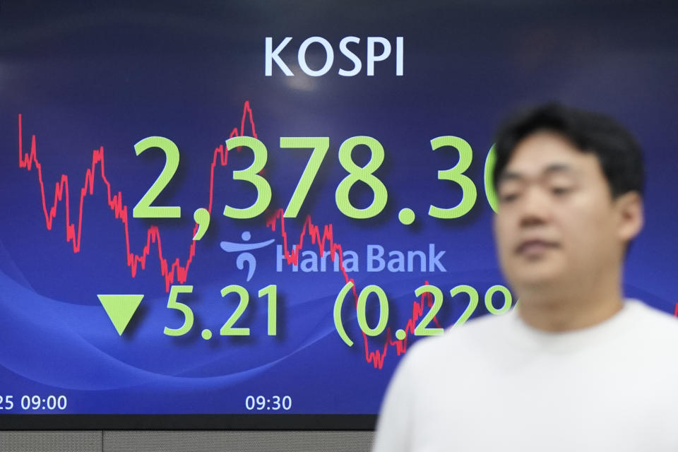 A currency trader walks by the screens showing the Korea Composite Stock Price Index (KOSPI) at a foreign exchange dealing room in Seoul, South Korea, Wednesday, Oct. 25, 2023. Asian shares advanced Wednesday, tracking gains on Wall Street after Verizon and other big companies reported fatter profits for the summer than expected. (AP Photo/Lee Jin-man)