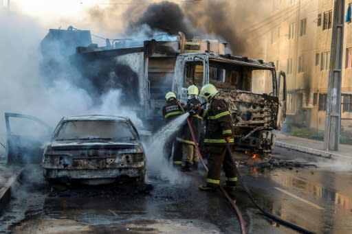 Firefighters put out a burning car during a wave of gang violence in northeast Brazil in January 2019, and experts warn such violence, as well as legal weapons and ammunition in gang possession, could increase after Bolsonaro's law