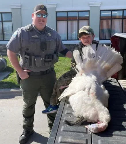 Chayson Emmons, 7, of Blue Springs, poses with the rare white turkey he shot on Saturday as part of youth turkey season.
