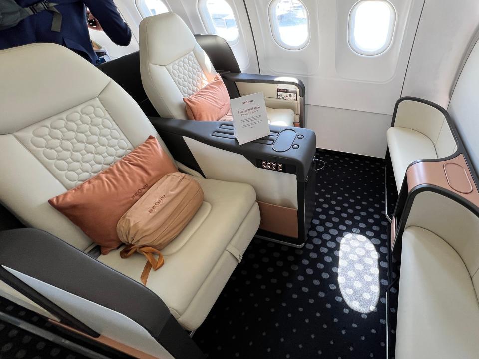 Two seats at the front of Beond's A319 in a cream leather, with foot stools