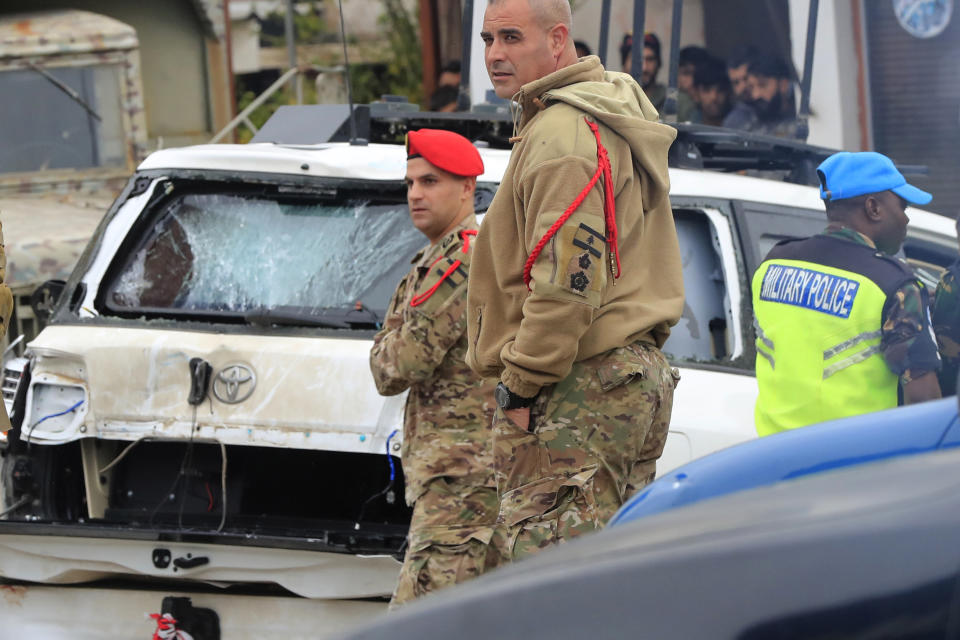 Lebanese soldiers stand next to a damaged UN peacekeeper vehicle at the scene where a UN convoy came under gunfire in the Al-Aqbiya village, south Lebanon, Thursday, Dec. 15, 2022. (AP Photo/Mohammed Zaatari)