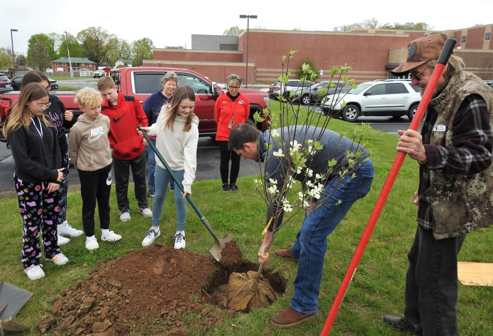 Tom Kistler and Jim Marcentile helped sixth grade student council members at Coshocton Elementary School to plant a tree at the campus for Arbor Day donated by the Coshocton Tree Commission, in this file photo.
